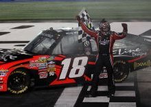 Kyle Busch grabs the checkered flag to celebrate his win in the North Carolina Education Lottery 200 at Charlotte Motor Speedway. Credit: Streeter Lecka/Getty Images for NASCAR