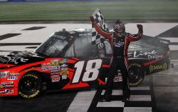 Kyle Busch grabs the checkered flag to celebrate his win in the North Carolina Education Lottery 200 at Charlotte Motor Speedway. Credit: Streeter Lecka/Getty Images for NASCAR